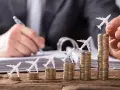 Pequeños aviones sobre pilas de monedas crecientes, simbolizando cómo viajar barato es posible con planificación.