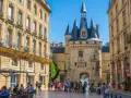 La Porte Cailhau y edificios históricos en Burdeos. Un lugar ideal que ver en Burdeos, con gente paseando y terrazas.