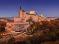 Impresionante Alcázar de Segovia al atardecer. Un lugar mágico que ver en Segovia en un día, con su silueta sobre el paisaje.