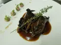 Plato de caza en salsa oscura, decorado con tomillo y puré de patatas. ¡Una opción deliciosa donde comer en Úbeda!