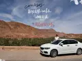 Consejos para alquilar coche y conducir en Marruecos. Paisaje desértico con palmeras y una mujer junto a un coche blanco.