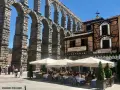 Mesón de Candido, un lugar ideal donde comer en Segovia, bajo el imponente acueducto. Mesas al aire libre.