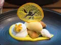 Postre de autor con helado de limón, merengue, bizcocho y naranja deshidratada. ¡Una delicia para saber dónde comer en Barcelona!