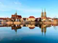 Imponente skyline de Breslavia, Polonia, con sus iglesias y edificios históricos reflejados en el sereno río Odra.