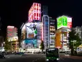 Noche vibrante en Tokio, con luces de neón y anuncios de anime. Ideal para saber qué ver en Tokio en 3 días.