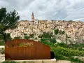 Cartel de "Bocairent" con el pueblo al fondo. Descubre qué ver en Bocairent, un pueblo colgado en la roca.
