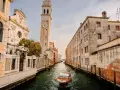 Un canal veneciano con un barco de madera y edificios antiguos. ¿Cuántos días para ver Venecia?