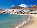 Pueblo blanco a orillas del mar turquesa, ideal para descubrir qué ver en Cabo de Gata. Playas doradas y casas encaladas bajo un cielo azul.