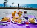 Desayuno frente al mar en Calpe: cruasanes, tostadas, fruta fresca, yogur y café. ¡Un lugar ideal donde comer en Calpe!