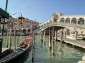 Góndola esperando en el canal, con el Puente de Rialto al fondo. Ideas para que ver en Venecia en dos días.