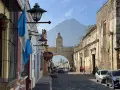 Calle empedrada en Antigua Guatemala, con el arco de Santa Catalina y el volcán de Agua al fondo. Ideal para descubrir qué ver en Antigua Guatemala.
