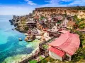 Un pintoresco pueblo de pescadores en Malta en verano, con casas coloridas y aguas turquesas.