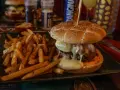 Jugosa hamburguesa con queso fundido y patatas fritas, ideal para saber donde comer en Carcassonne.