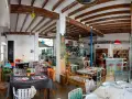 Un restaurante acogedor en Dénia, con mesas coloridas y vigas de madera. Ideal para saber donde comer en Dénia.