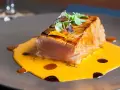 Un delicioso atún sellado sobre una cremosa salsa de naranja, perfecto para comer en Cambados.