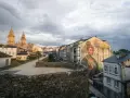 Mural de mujer en edificio, con la muralla romana y la catedral al fondo. Imprescindible que ver en Lugo.