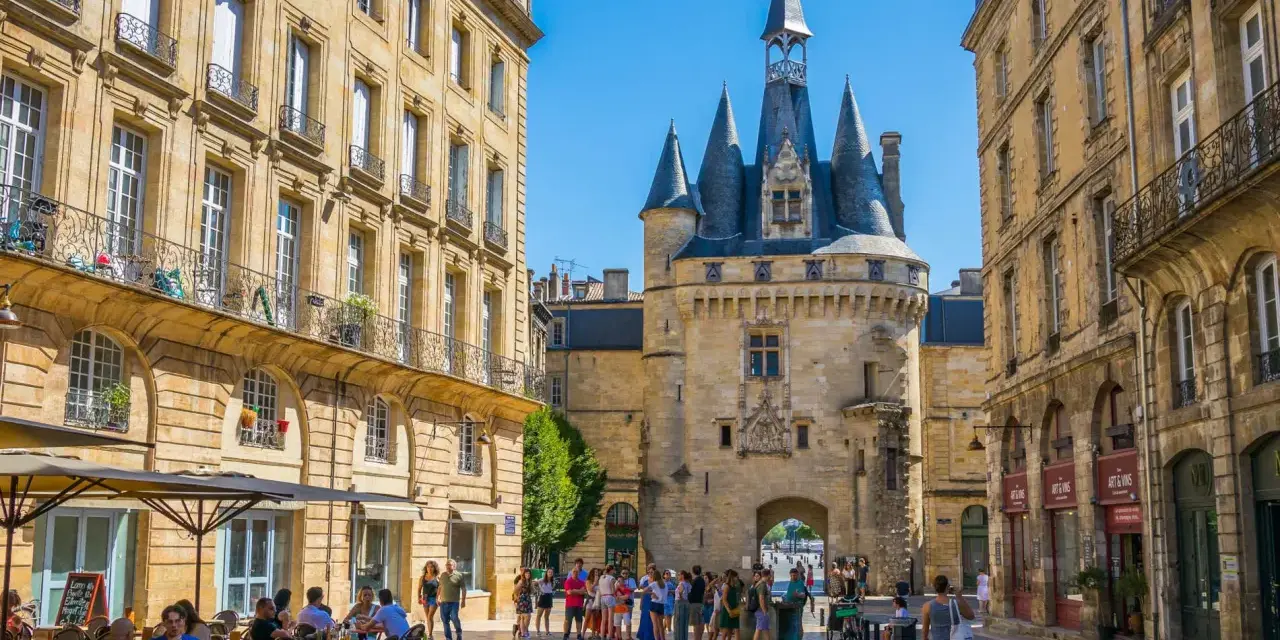 La Porte Cailhau y edificios históricos en Burdeos. Un lugar ideal que ver en Burdeos, con gente paseando y terrazas.