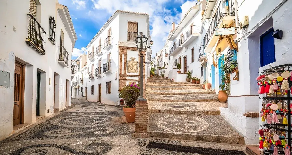 Calle empedrada con diseño de guijarros, casas blancas y escalinata. Un rincón perfecto para tu ruta Andalucía 7 días.
