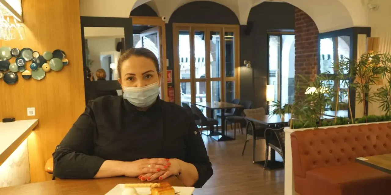 Chef con mascarilla en un restaurante moderno, ideal para saber donde comer en Zafra. Postre en primer plano.
