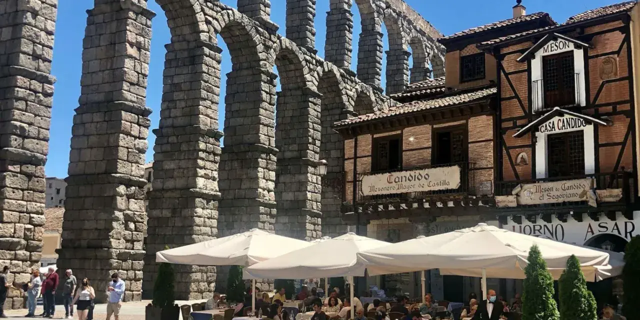 Mesón de Candido, un lugar ideal donde comer en Segovia, bajo el imponente acueducto. Mesas al aire libre.