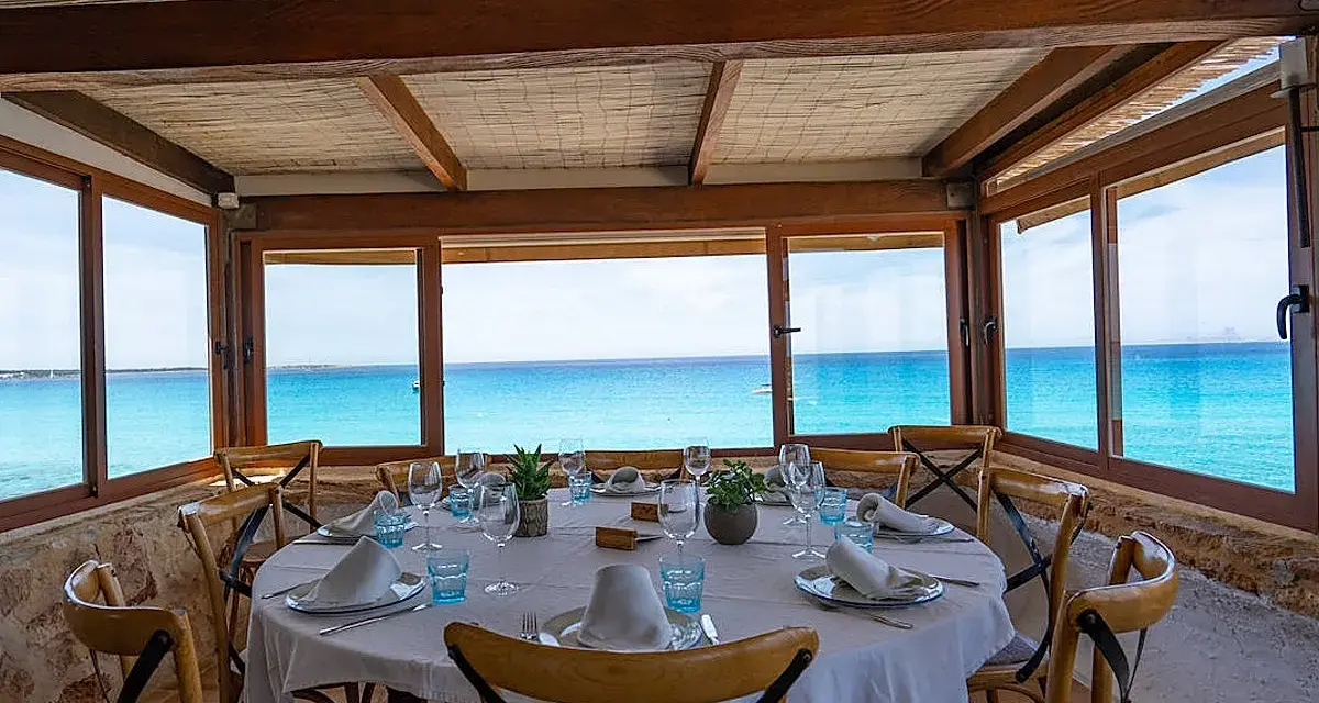 Mesa puesta con vistas al mar turquesa, ideal para saber donde comer en Formentera.