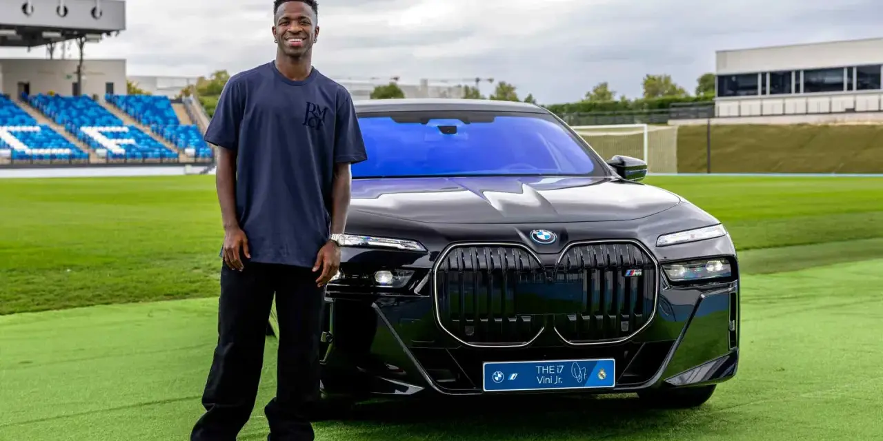 Vinícius Jr. posa junto a un BMW eléctrico en Madrid, disfrutando de las ventajas de un coche eléctrico en la ciudad.