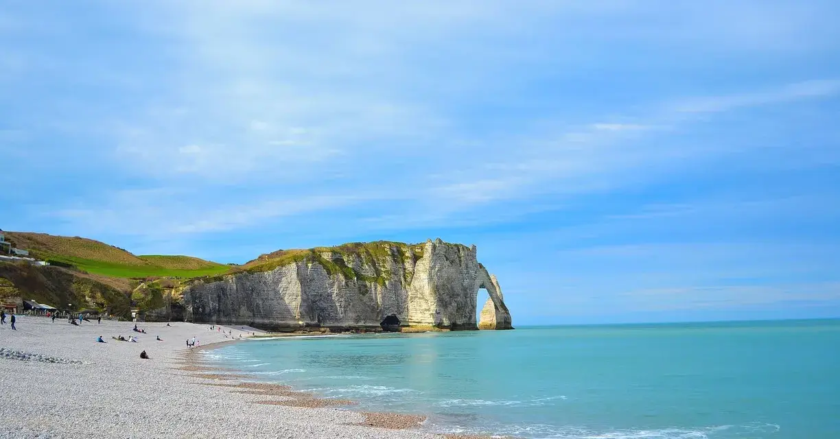 Acantilados impresionantes y playa de guijarros en Étretat, un lugar imperdible que ver en Normandía.