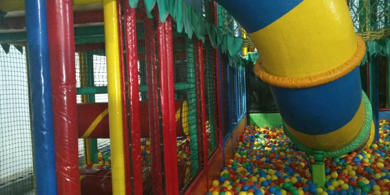 Parque infantil en Gijón con niños, perfecto para un día de lluvia. ¡A disfrutar de las bolas de colores!