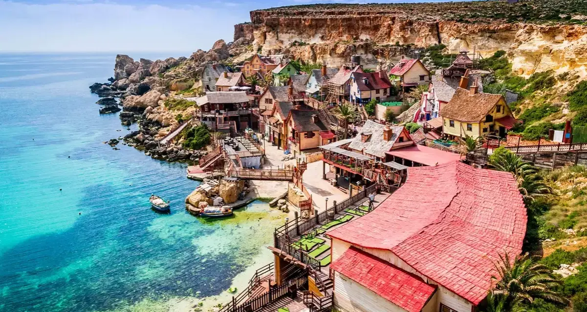 Un pintoresco pueblo de pescadores en Malta en verano, con casas coloridas y aguas turquesas.