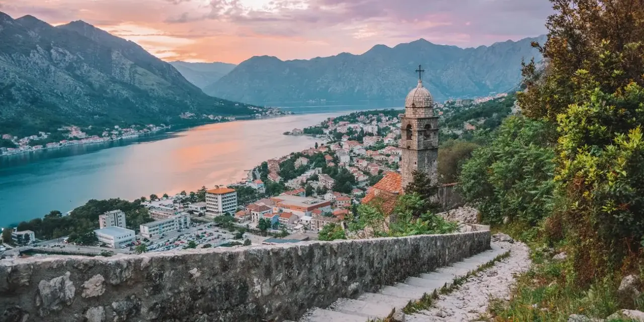 Vista de Kotor, Montenegro, al atardecer. Un lugar ideal donde viajar en julio barato, con vistas a la bahía y montañas.