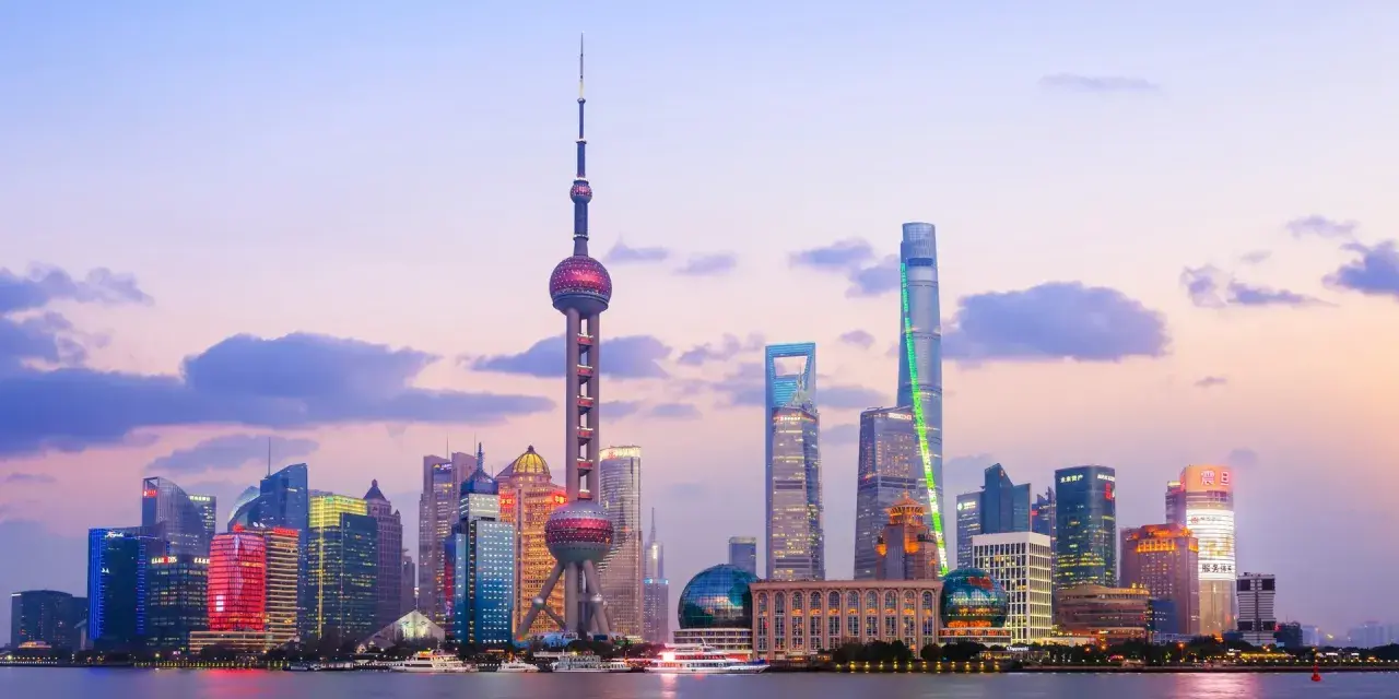 El horizonte de Shanghái al atardecer, con la Torre de la Perla Oriental y rascacielos iluminados. Un sueño para un viaje a China 10 días.