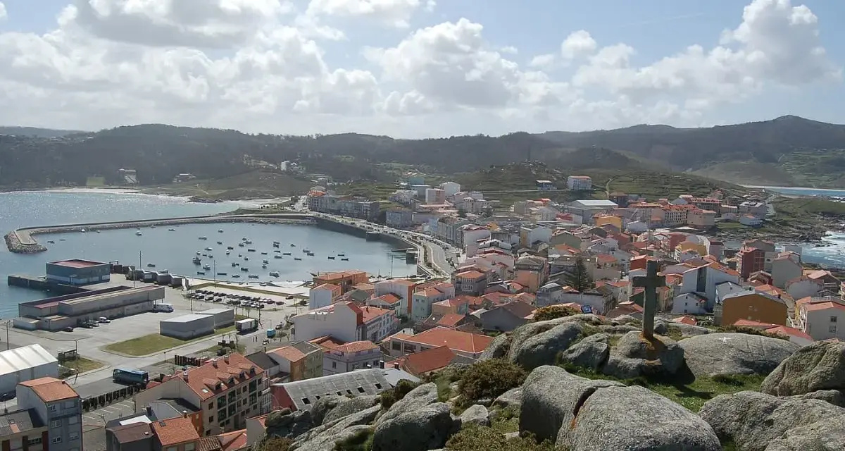 Vista panorámica de Muxía, con su puerto y casas de tejados rojos. Un lugar perfecto para comer y disfrutar del paisaje.