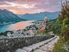 Vista de Kotor, Montenegro, al atardecer. Un lugar ideal donde viajar en julio barato, con vistas a la bahía y montañas.