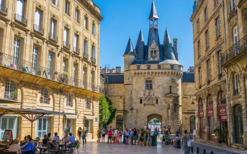 La Porte Cailhau y edificios históricos en Burdeos. Un lugar ideal que ver en Burdeos, con gente paseando y terrazas.