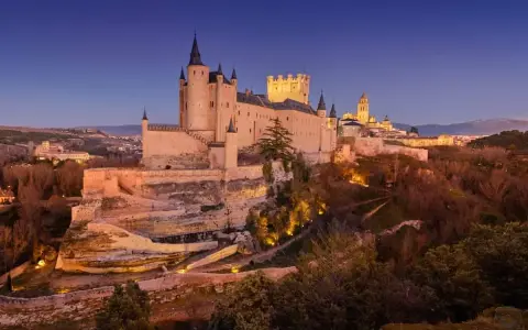Impresionante Alcázar de Segovia al atardecer. Un lugar mágico que ver en Segovia en un día, con su silueta sobre el paisaje.