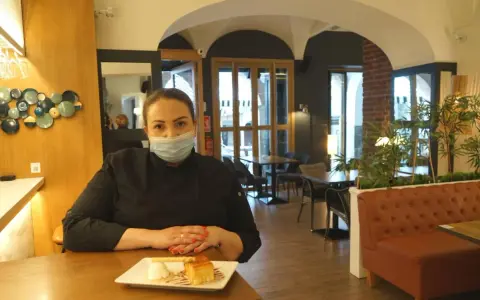 Chef con mascarilla en un restaurante moderno, ideal para saber donde comer en Zafra. Postre en primer plano.