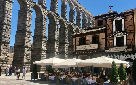 Mesón de Candido, un lugar ideal donde comer en Segovia, bajo el imponente acueducto. Mesas al aire libre.