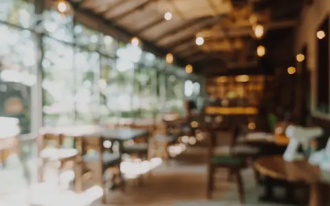 Ambiente acogedor para comer en Gandía, con mesas de madera y luces cálidas.