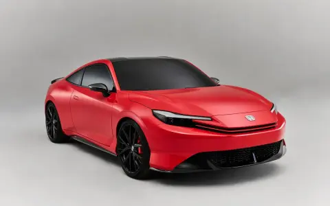 Coche deportivo rojo con techo negro, llantas negras y pinzas rojas. Los coches híbridos son automáticos, ofreciendo una conducción suave y eficiente.