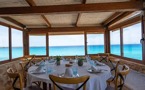 Mesa puesta con vistas al mar turquesa, ideal para saber donde comer en Formentera.