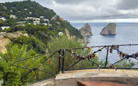 Vista de los Faraglioni, un clásico que ver en Capri. El balcón está adornado con candados de amor.