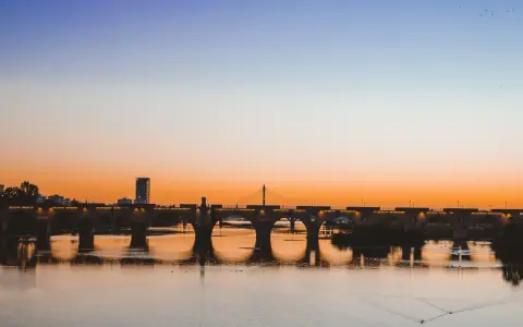 Atardecer sobre el río Guadiana, con el Puente de Palmas iluminado. Un paisaje idílico para descubrir qué ver en Badajoz.