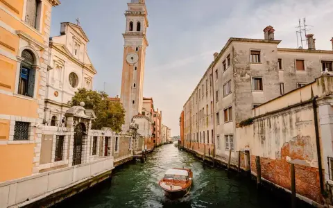 Un canal veneciano con un barco de madera y edificios antiguos. ¿Cuántos días para ver Venecia?