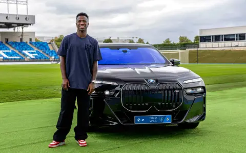 Vinícius Jr. posa junto a un BMW eléctrico en Madrid, disfrutando de las ventajas de un coche eléctrico en la ciudad.