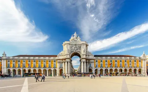 Arco da Rua Augusta y Praça do Comércio, un lugar ideal que ver en Lisboa en 3 días. Gente paseando bajo el cielo azul.