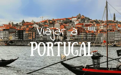 Barcos tradicionales navegan por el río Duero ante la colorida Ribeira de Oporto. ¡Un sueño para viajar a Portugal!