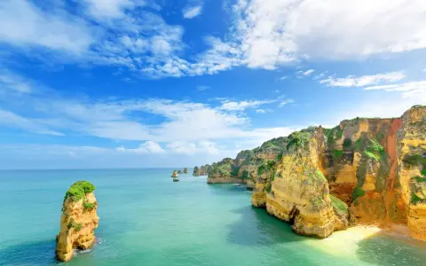 Acantilados dorados y mar turquesa. Un lugar idílico para saber donde viajar en agosto barato y disfrutar de la naturaleza.