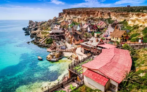 Un pintoresco pueblo de pescadores en Malta en verano, con casas coloridas y aguas turquesas.