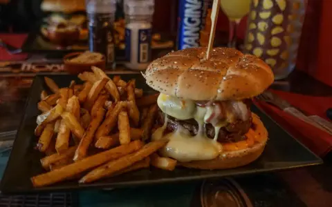 Jugosa hamburguesa con queso fundido y patatas fritas, ideal para saber donde comer en Carcassonne.
