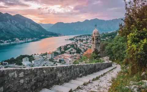Vista de Kotor, Montenegro, al atardecer. Un lugar ideal donde viajar en julio barato, con vistas a la bahía y montañas.